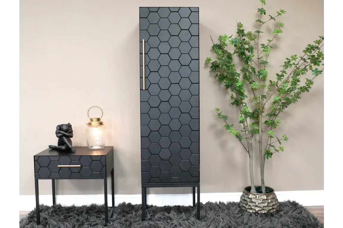 Black honeycomb pattern cabinet and matching side table with drawer, next to potted plant