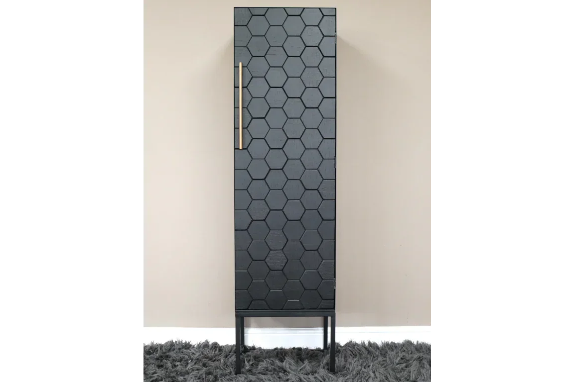 Tall black storage cabinet with hexagon pattern door and gold handle on grey rug