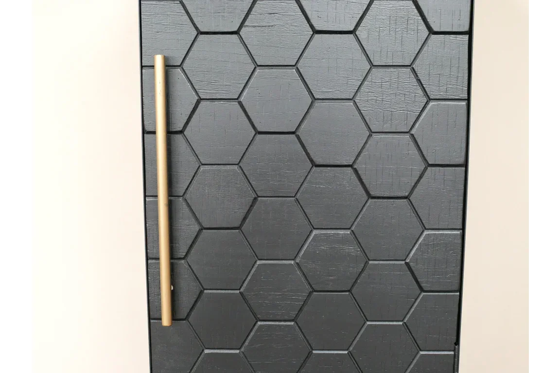 Black hexagon pattern cabinet door with long gold handle