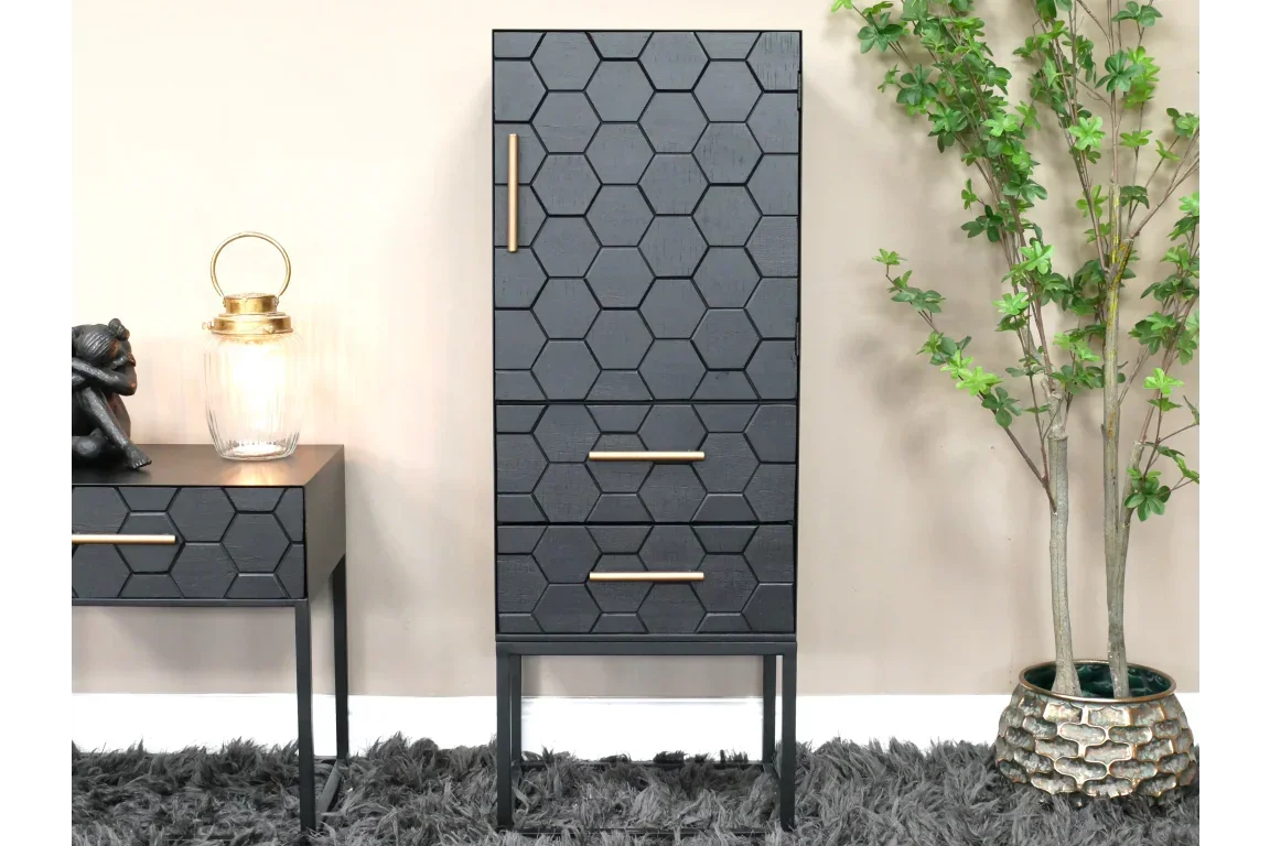 Black hexagon pattern cabinet with gold handles on shag rug next to decorative plant