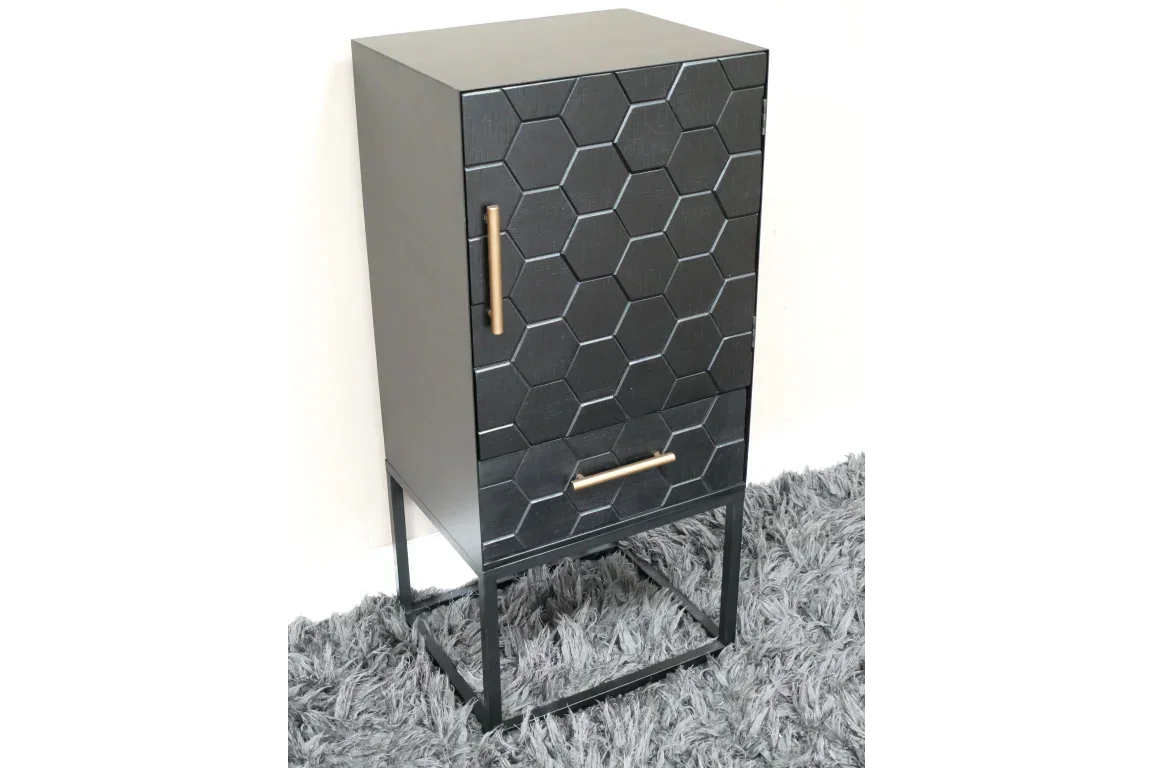 Black hexagonal pattern cabinet with gold handles on metal legs standing on grey rug