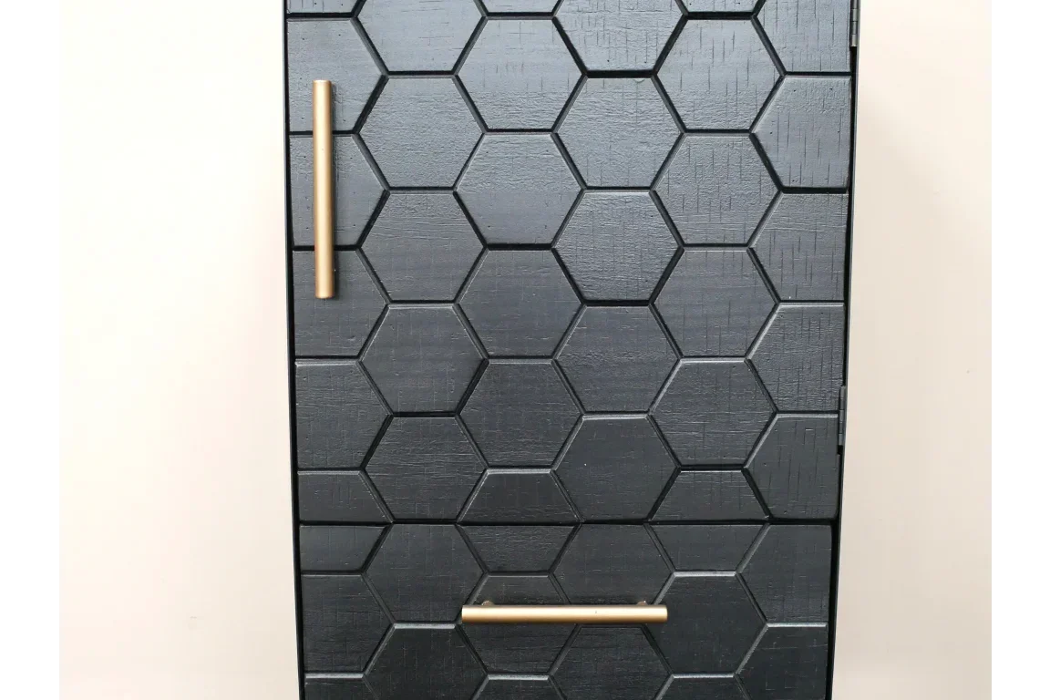 Black cabinet door with hexagon pattern and gold handles