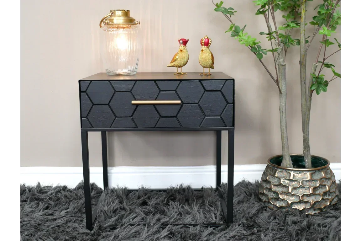 Black hexagon pattern bedside table with gold handle, styled with lamp and ornaments