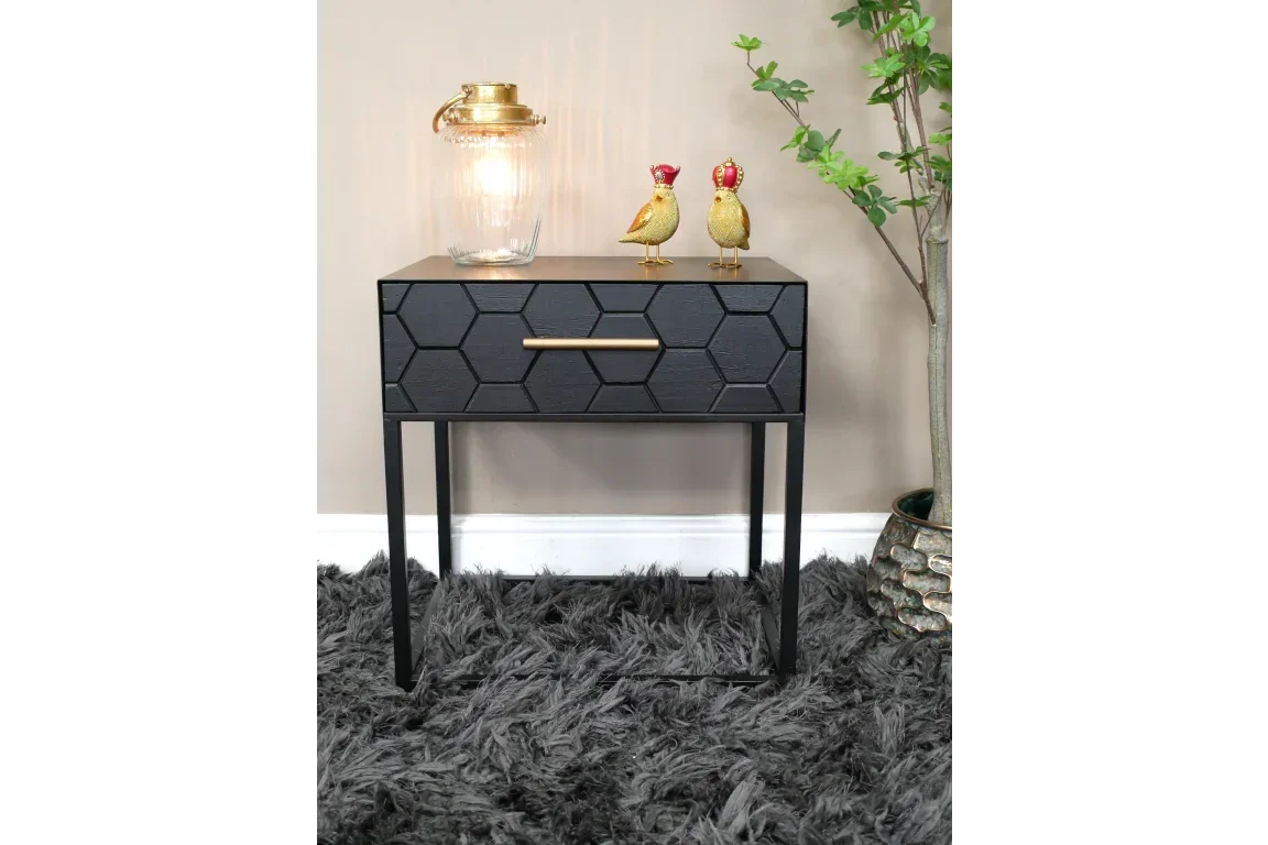 Black hexagon pattern bedside table with gold handle, lamp, and bird ornaments