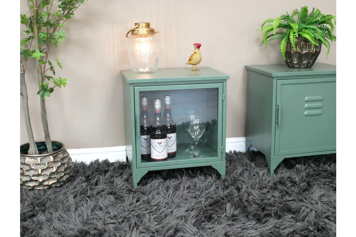 Green metal side cabinet with glass door, displaying wine bottles and glasses on grey rug