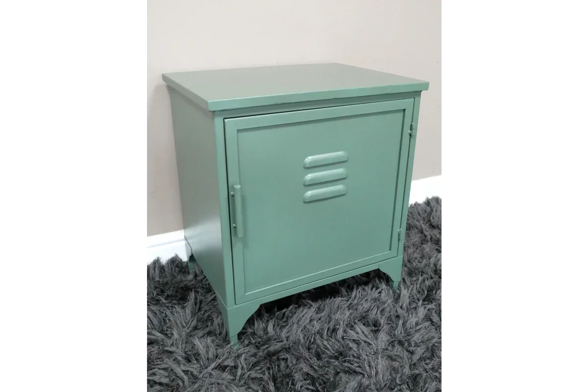 Green metal bedside cabinet with single door, vent detail, and handle on grey rug