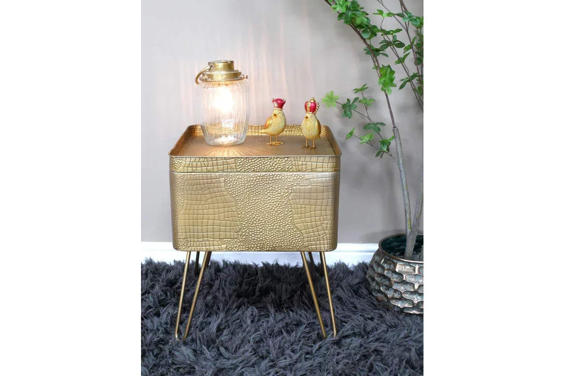 Gold side table with crocodile texture, lamp, decorative birds on shaggy rug