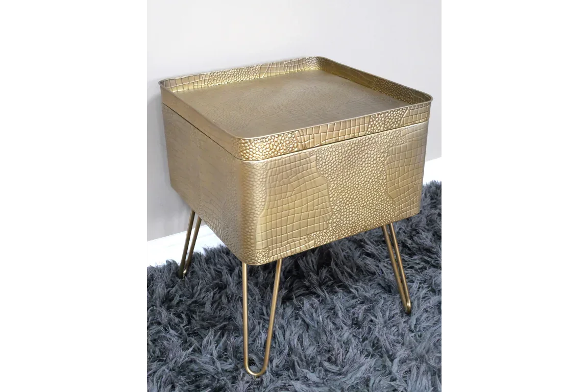 Gold textured metal side table with raised edges and hairpin legs on grey rug
