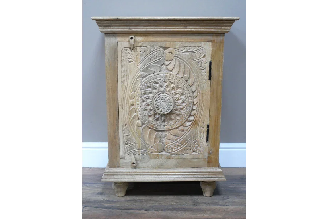 Carved wooden cabinet with ornate floral panels and short legs on wood floor