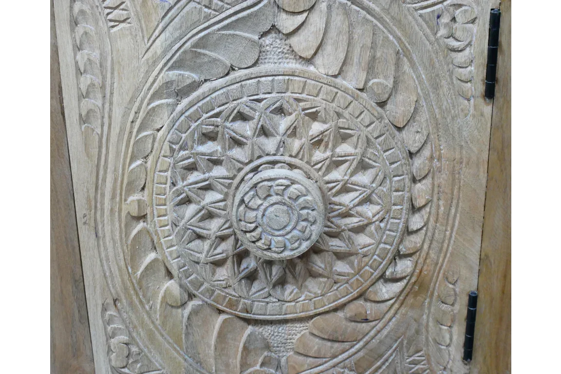 carved wood furniture panel with circular geometric mandala pattern and light natural finish