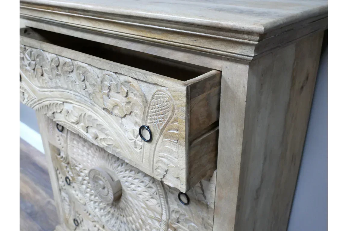 Carved wooden chest of drawers with ornate detail and open top drawer