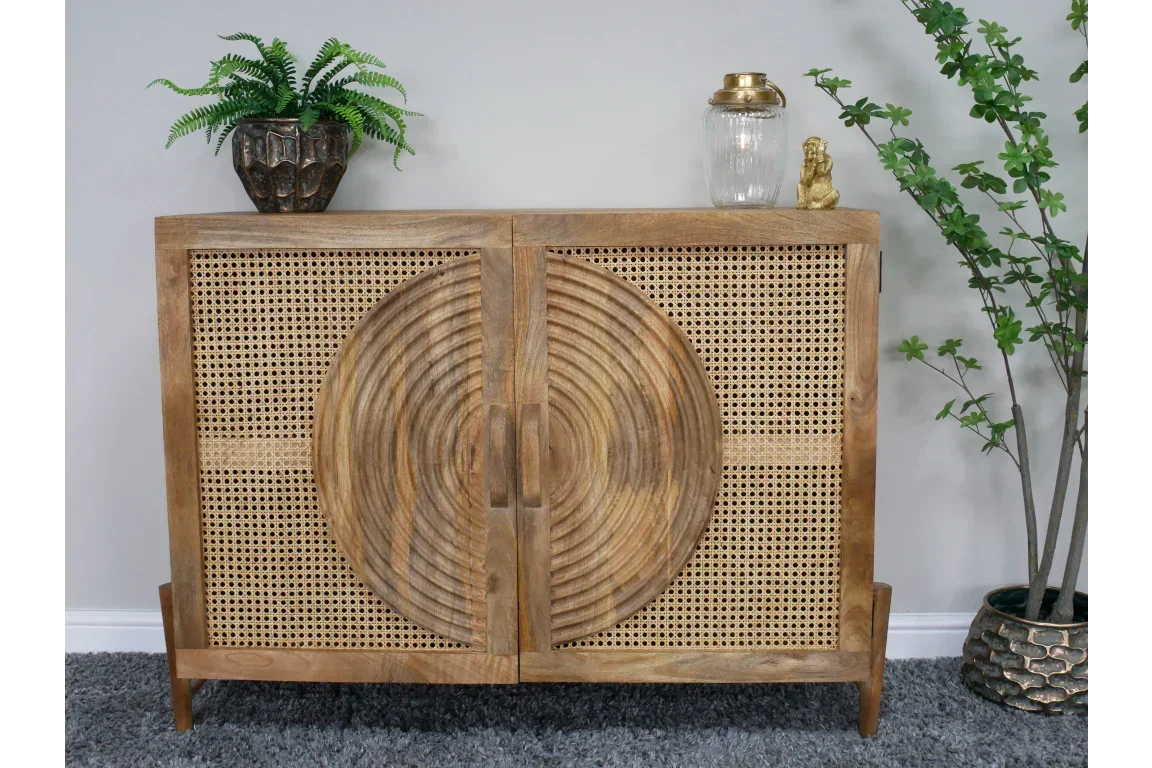 Wooden sideboard with rattan doors and carved circular pattern, styled with plants