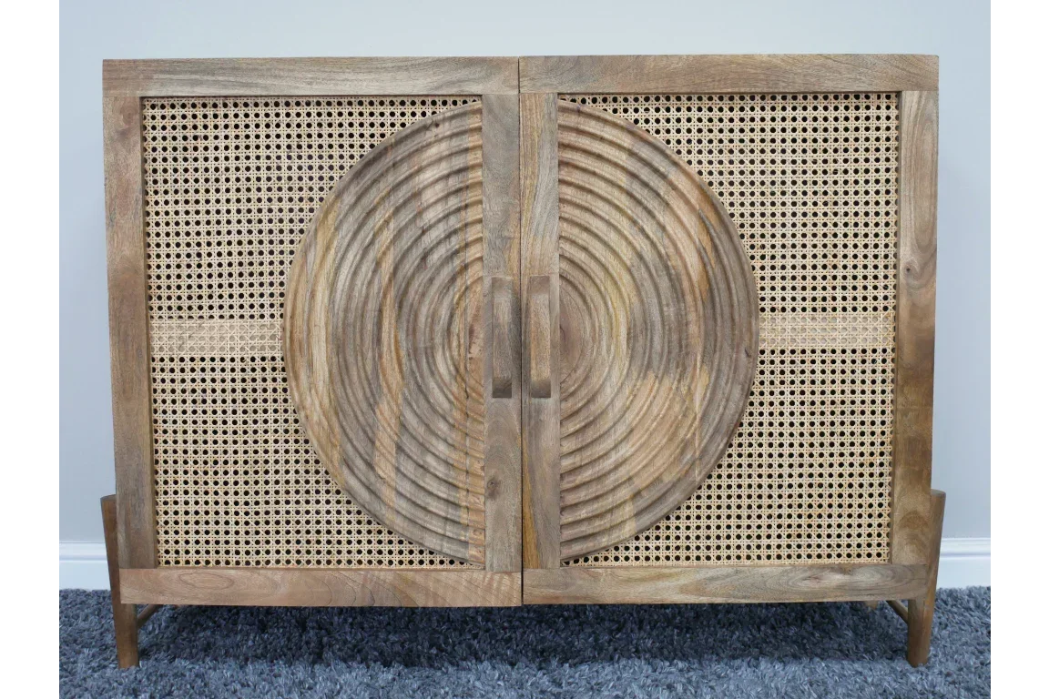 Wooden sideboard with rattan doors and carved circular pattern on front, on grey rug