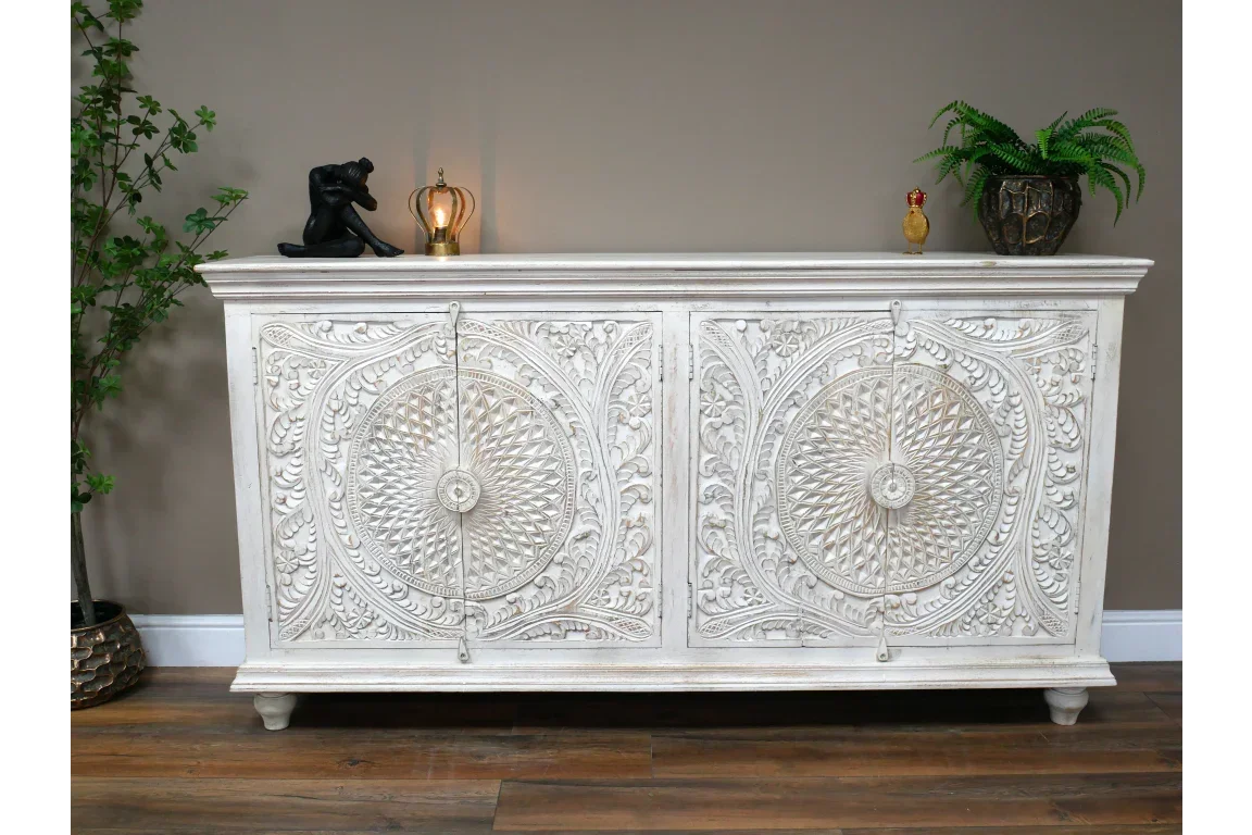 White carved sideboard with ornate floral patterns, wooden legs and decorative circular design