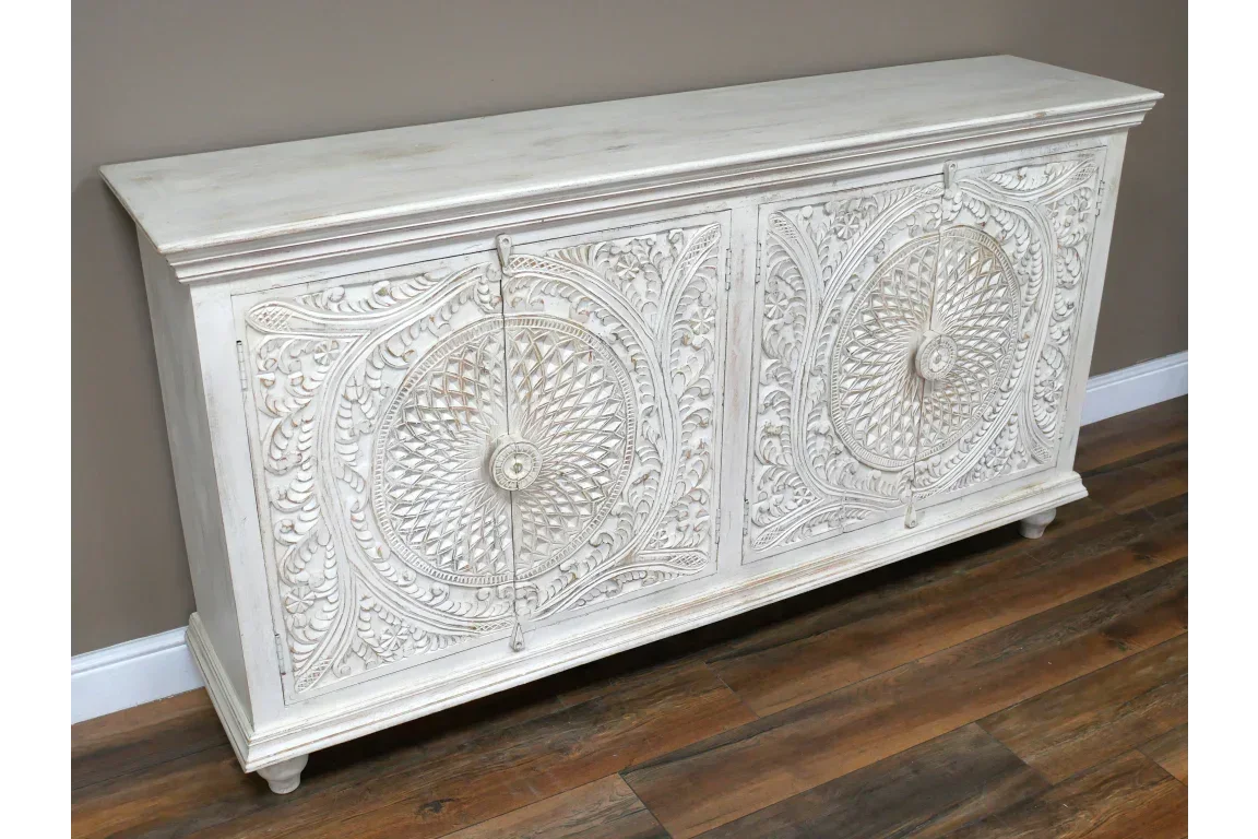 White carved wooden sideboard with intricate floral patterns and two cabinet doors