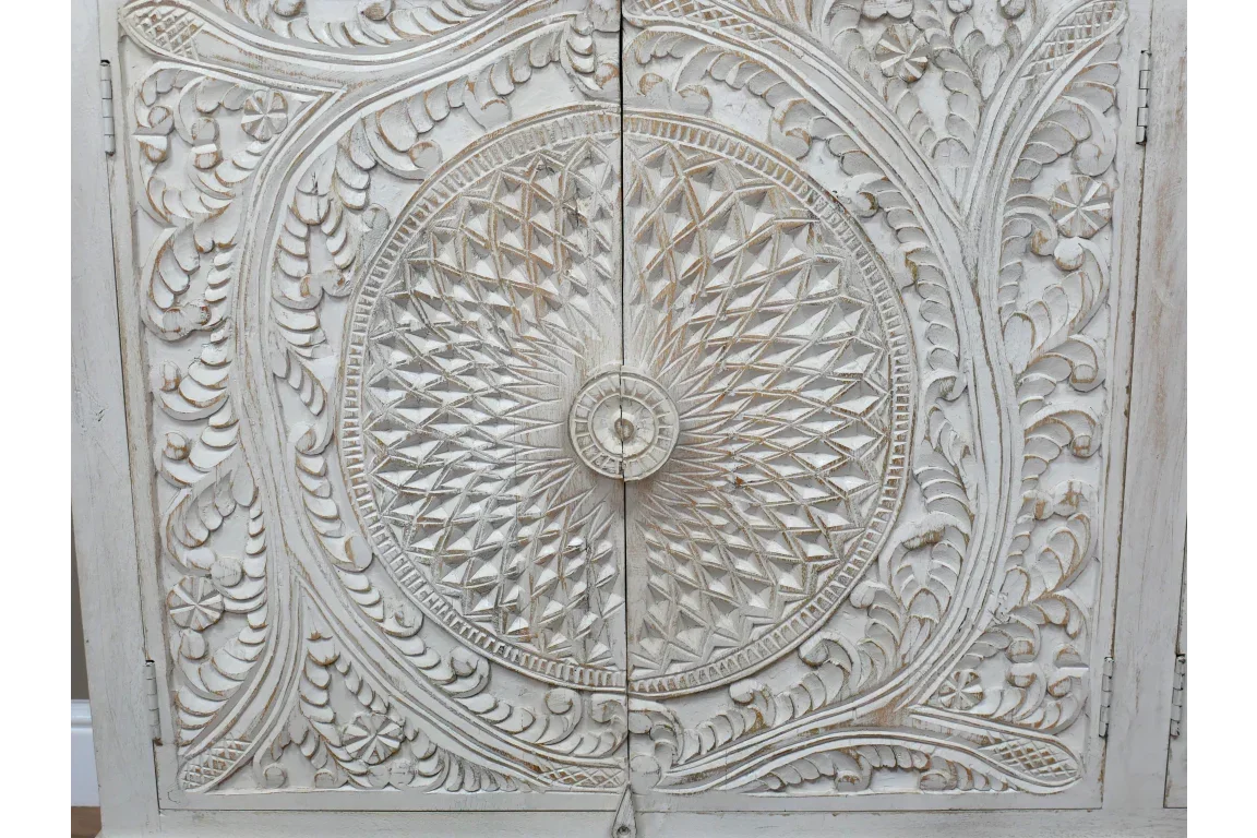 White carved wood cabinet doors with detailed circular and floral patterns