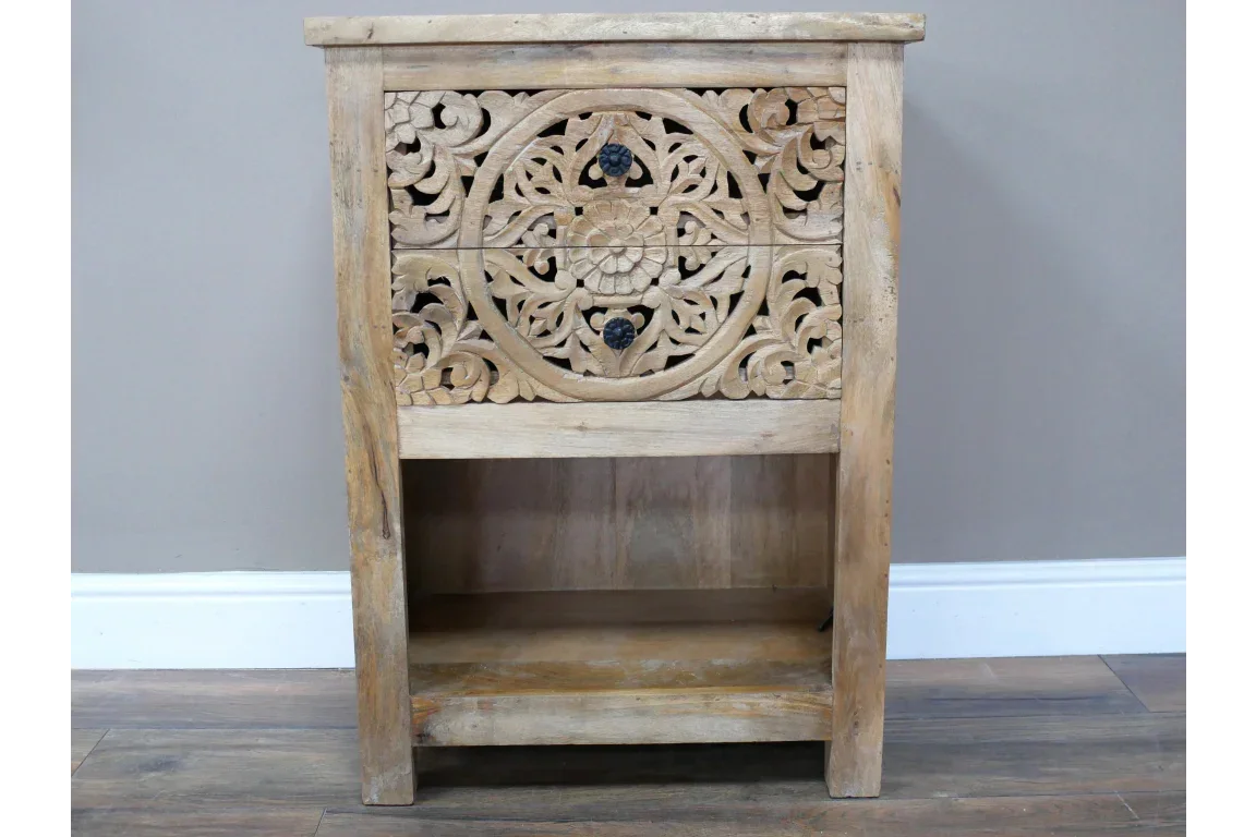 Wooden bedside table with carved floral drawer and open shelf on wooden floor