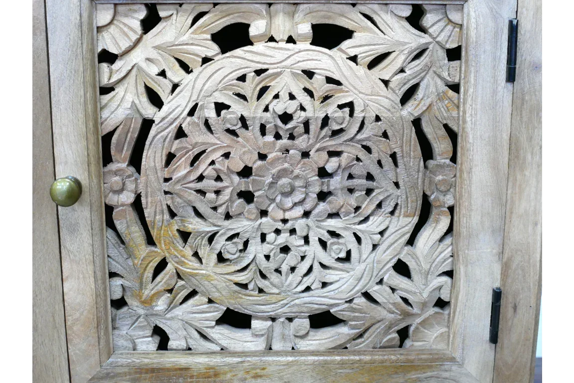 Carved wooden cabinet door with intricate floral panel and brass knob