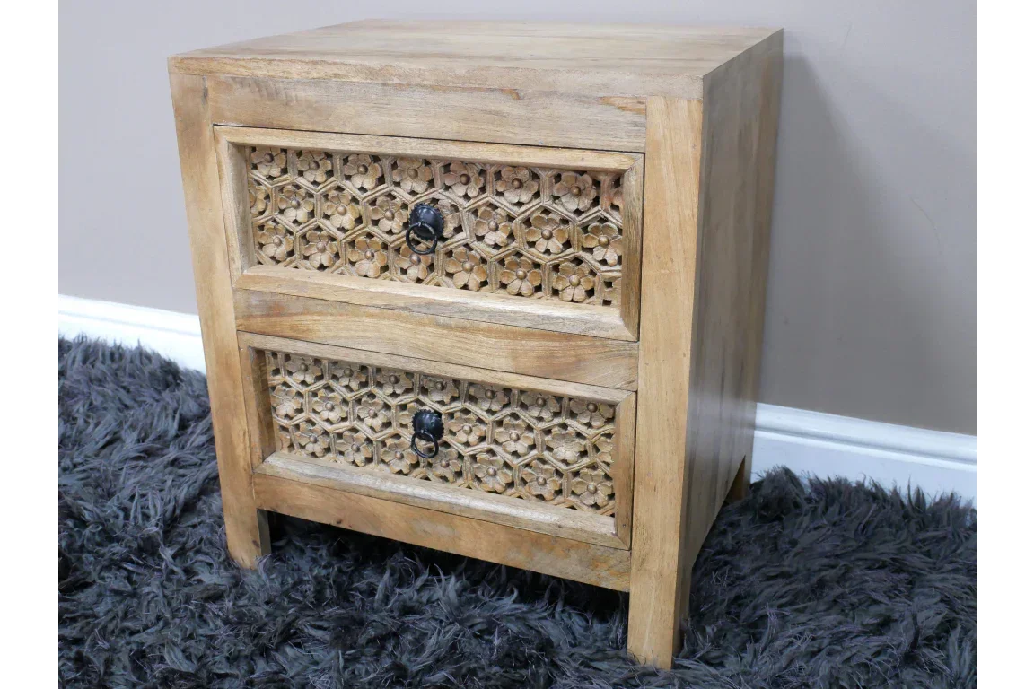 Wooden bedside cabinet with two carved drawers and black metal handles on grey rug