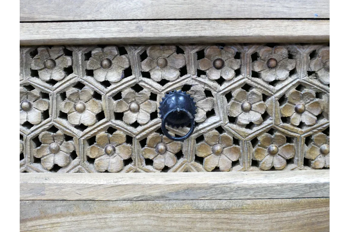 carved wood drawer front with floral pattern and black metal ring handle