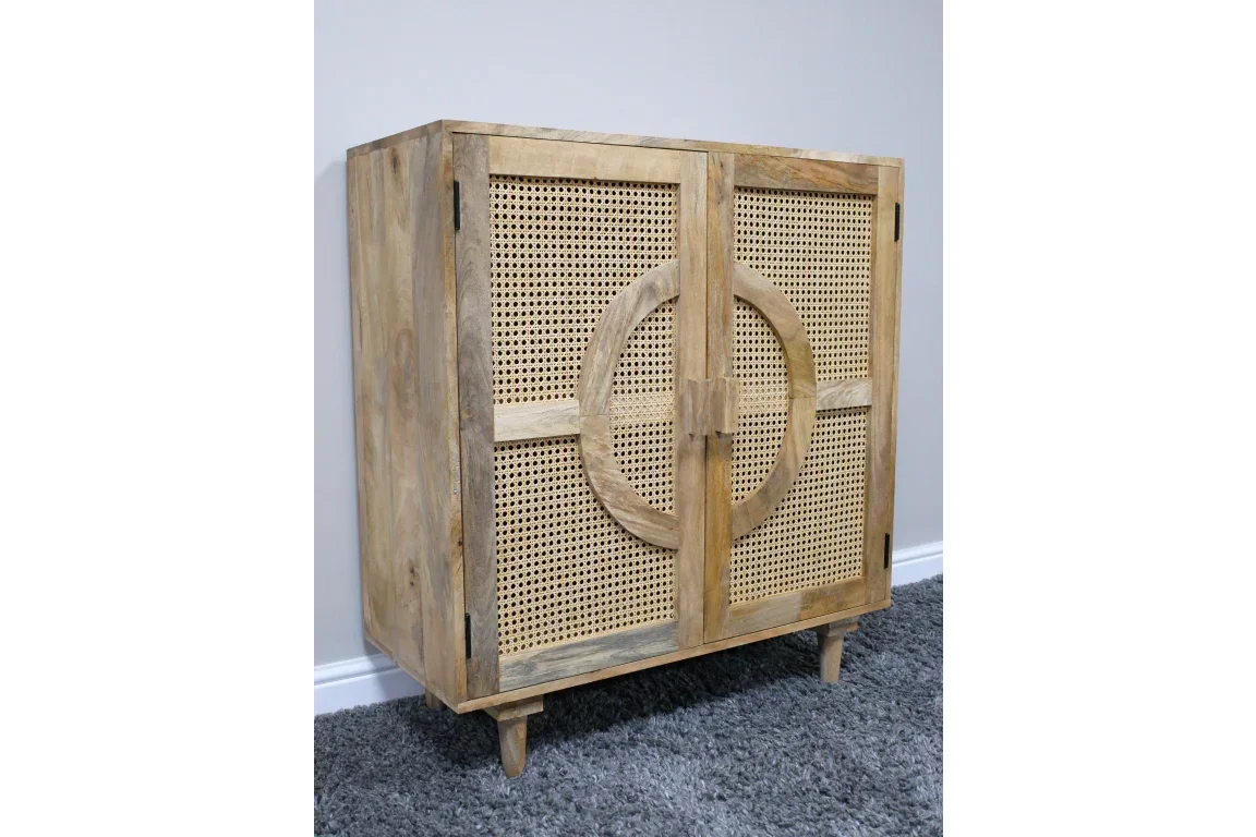 Natural wood sideboard with cane doors and circle detail, placed on grey carpet