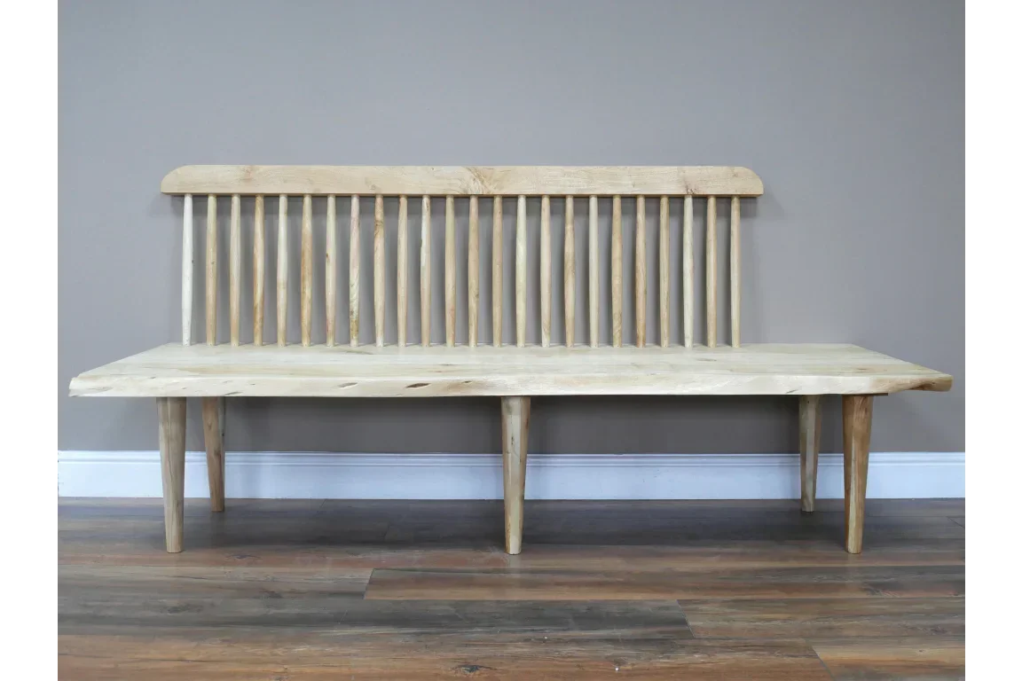 Natural wood bench with spindle backrest and tapered legs on wooden floor