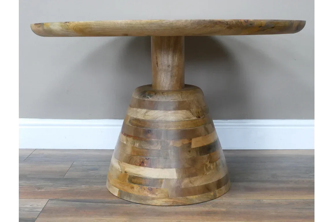 Round solid wood dining table with conical base and natural finish on wooden floor