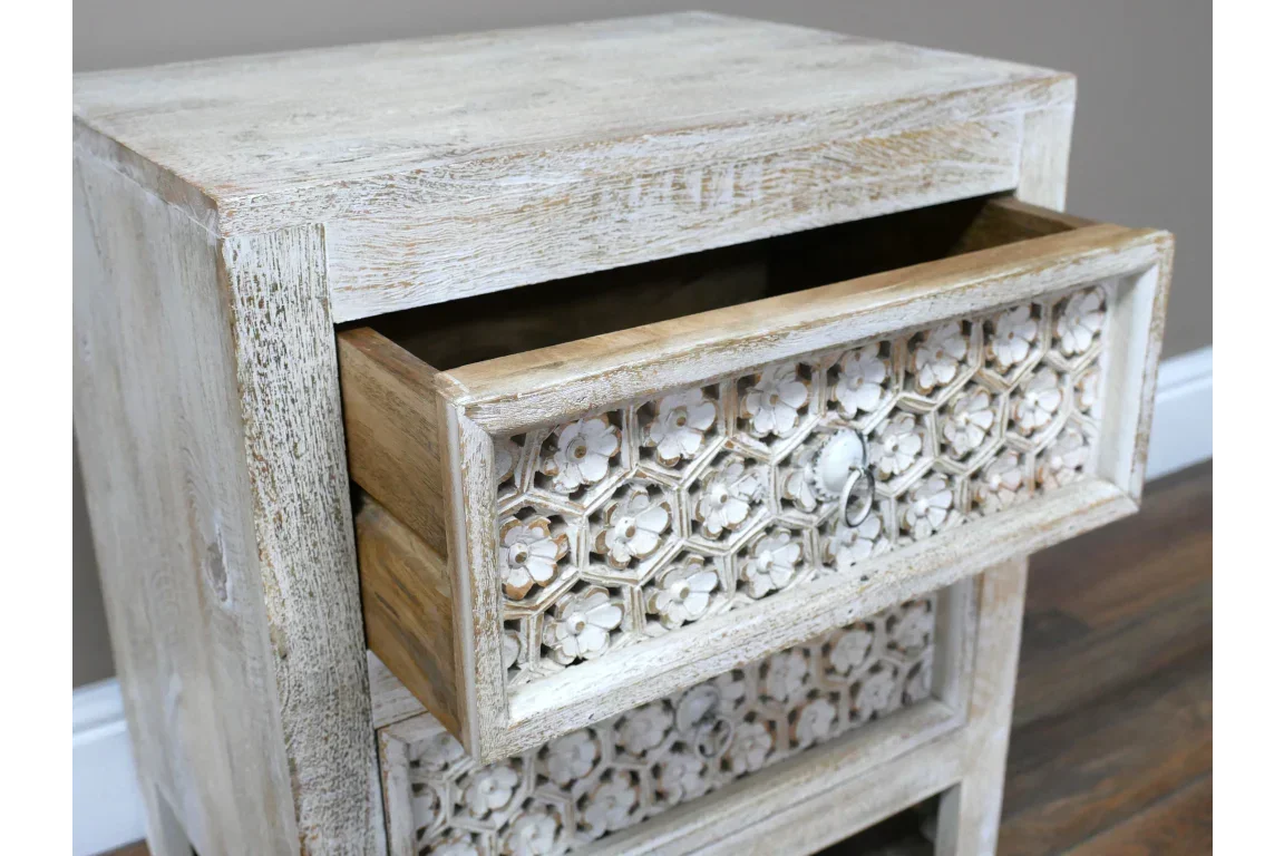 Carved wood bedside table with open drawer and floral pattern front, whitewashed finish