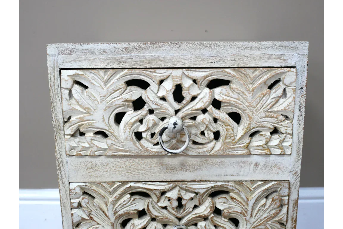 Whitewashed wooden drawer with carved floral pattern and metal ring handle