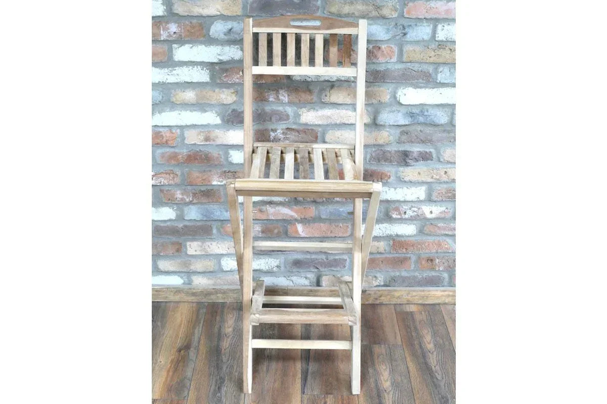 Slatted wooden bar stool with backrest and footrest on wood floor against brick wall
