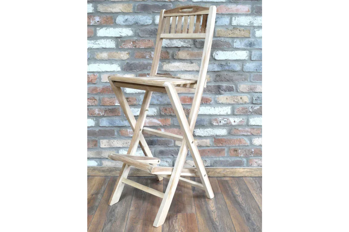 Wooden folding bar stool with slatted backrest on wood floor, brick wall background
