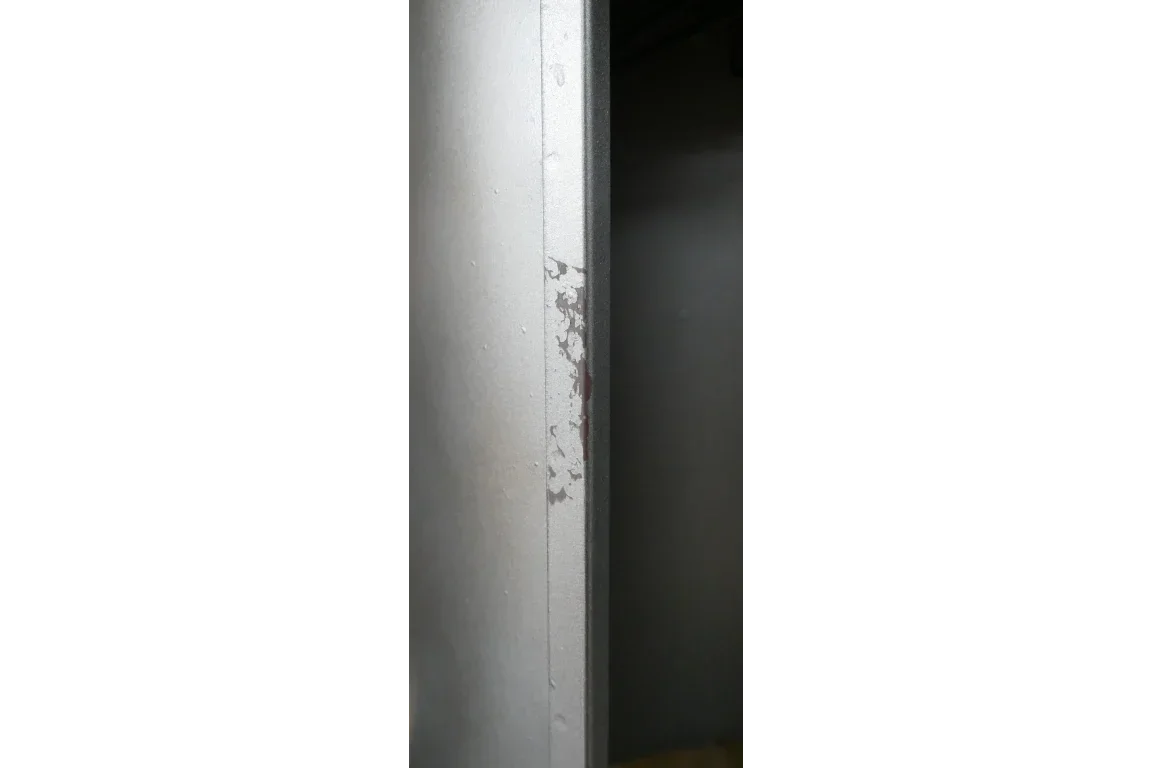 Close-up of metal cabinet with visible paint chipping along vertical edge