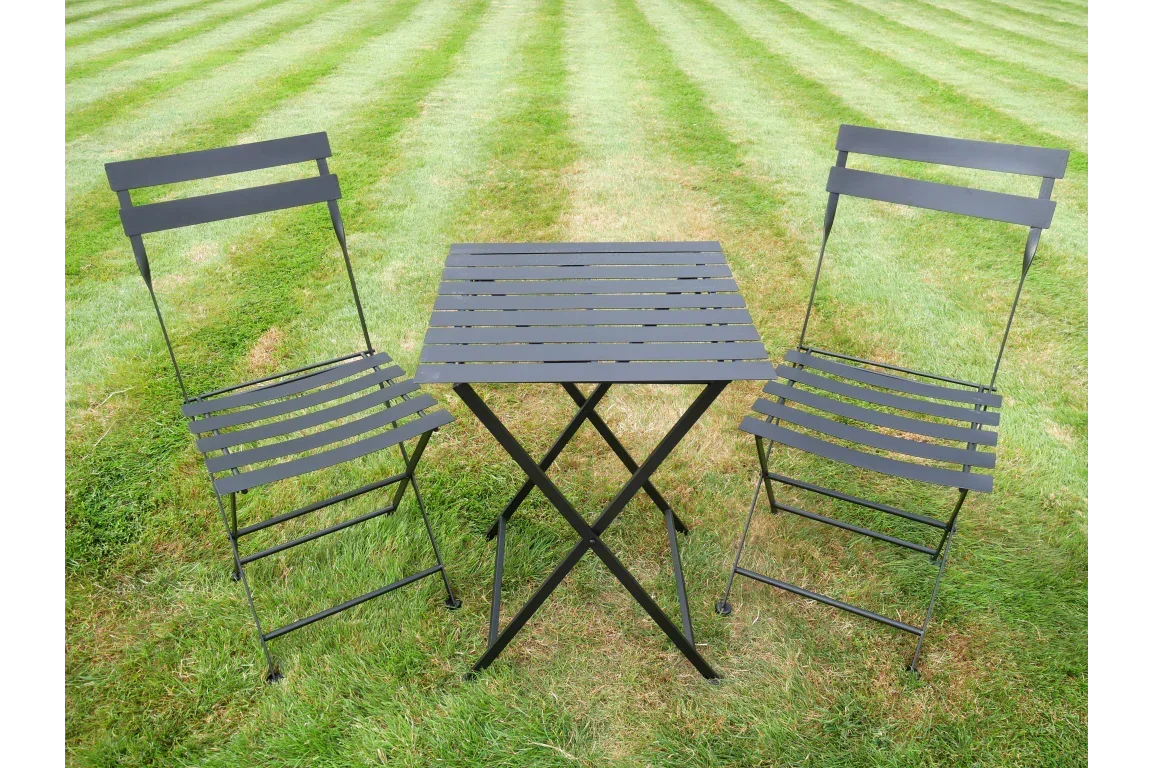 Black metal bistro set with slatted table and two chairs on outdoor lawn