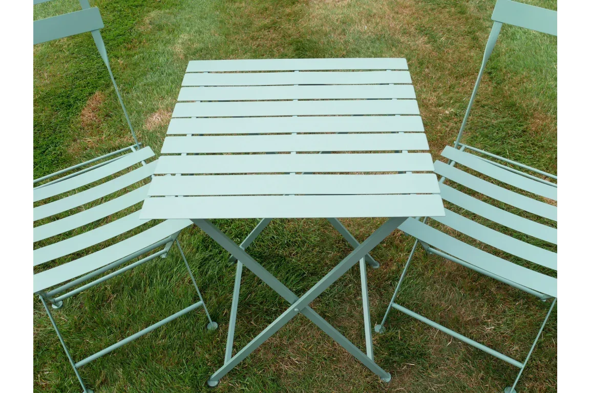 Metal garden bistro set with square table and two chairs on grass