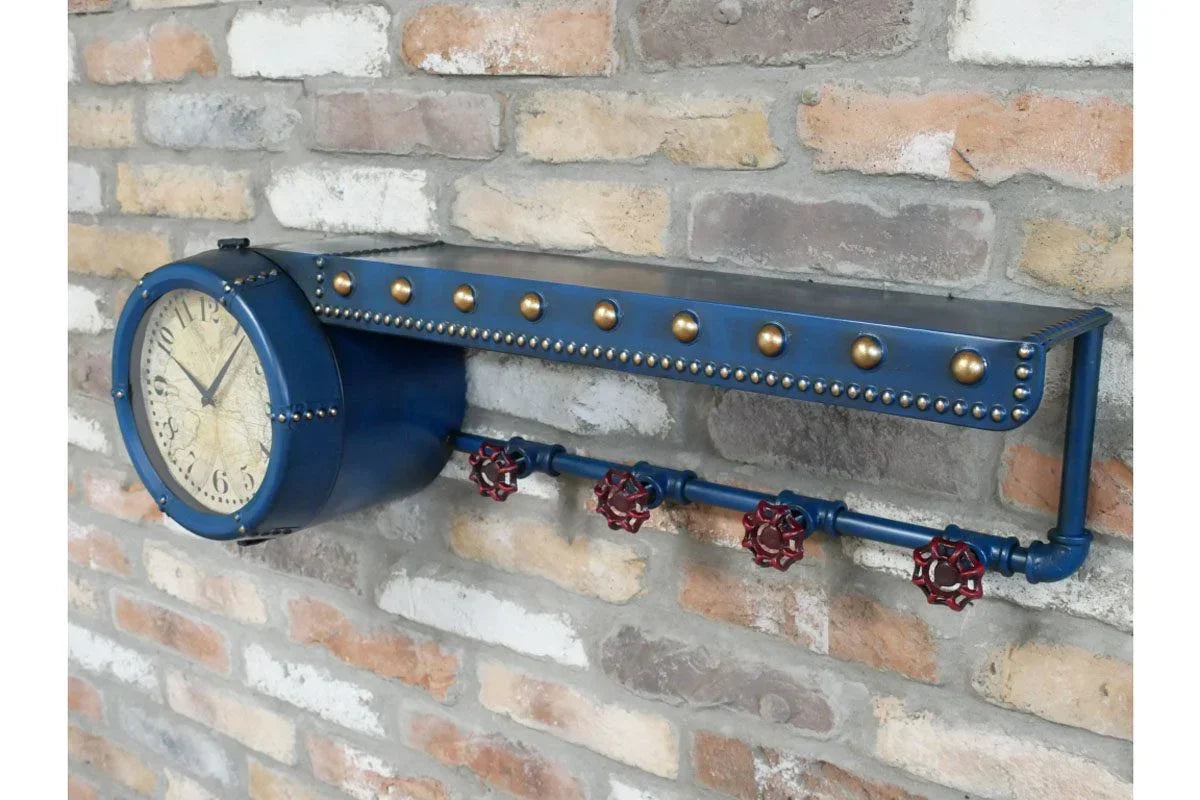 Industrial wall clock with blue metal frame, brass studs, and valve hooks on brick wall