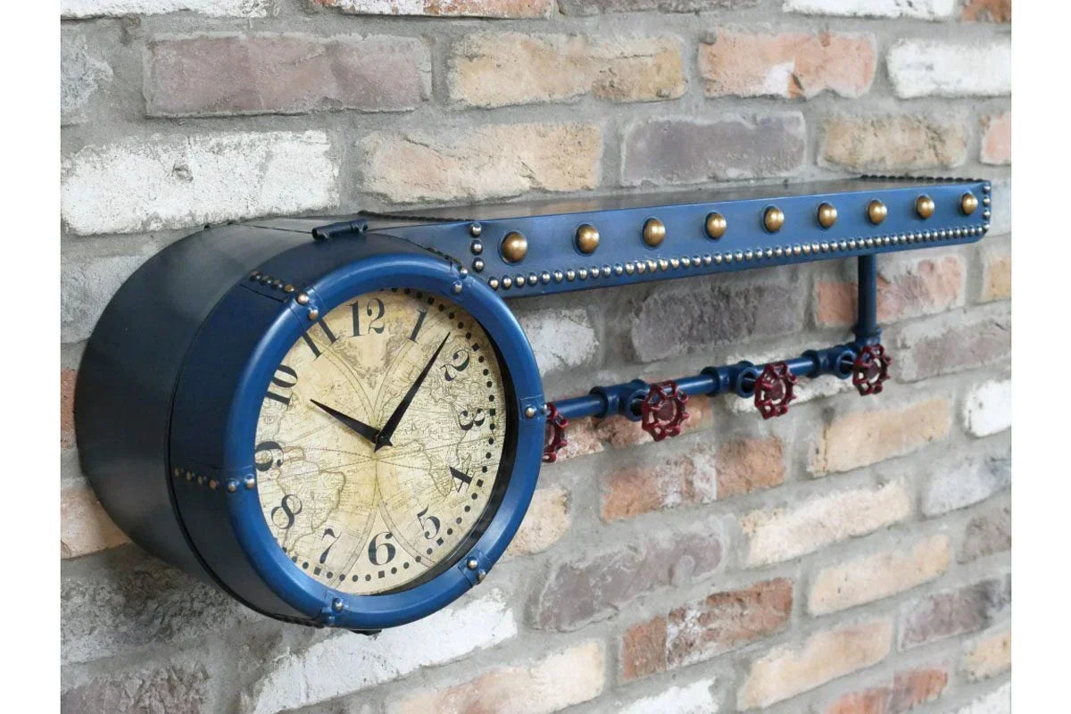 Industrial wall clock with blue metal frame and brass studs mounted on exposed brick