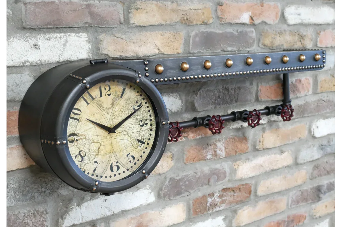 Industrial wall clock with metal frame and pipe hooks mounted on brick wall