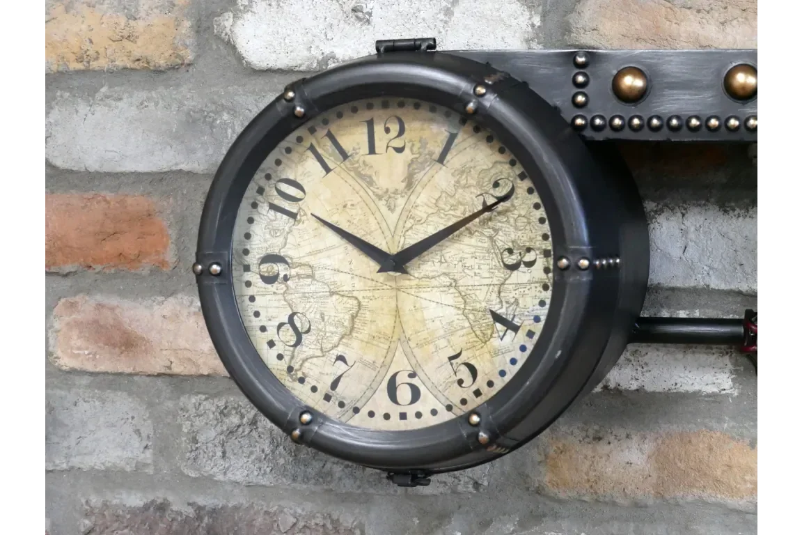 Industrial wall clock with metal frame and vintage map face mounted on brick wall