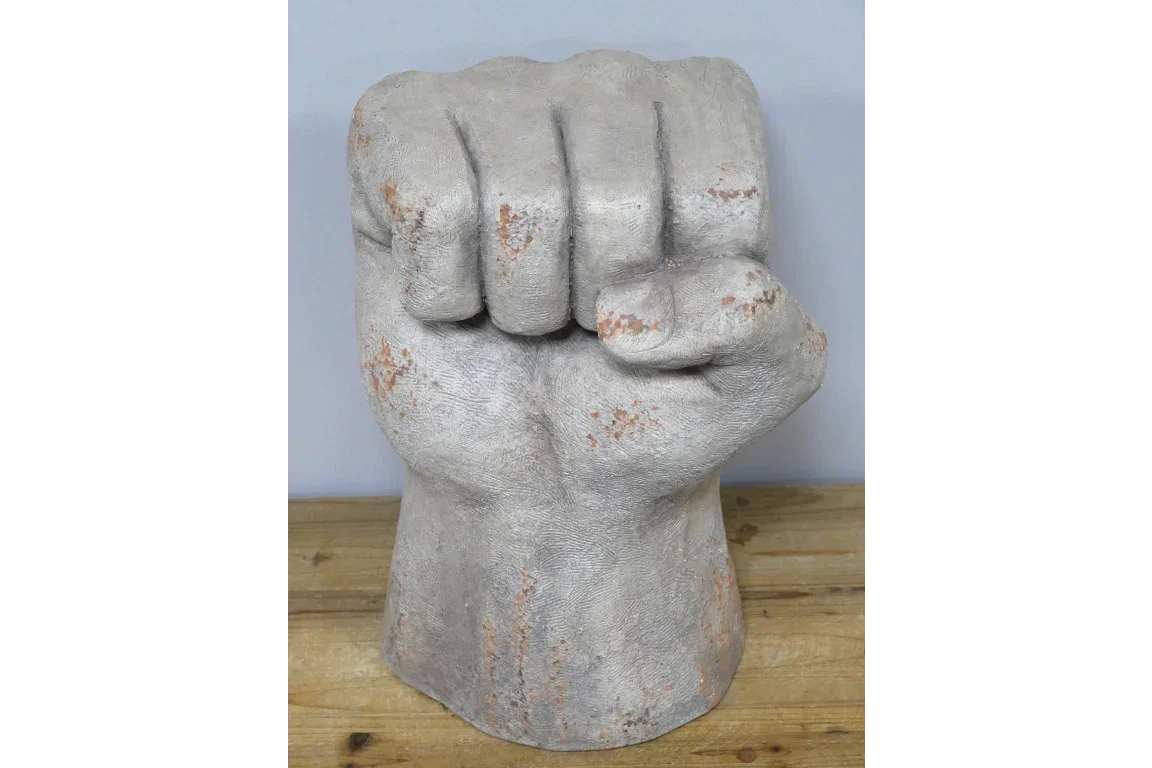 Stone effect fist sculpture ornament on wooden surface