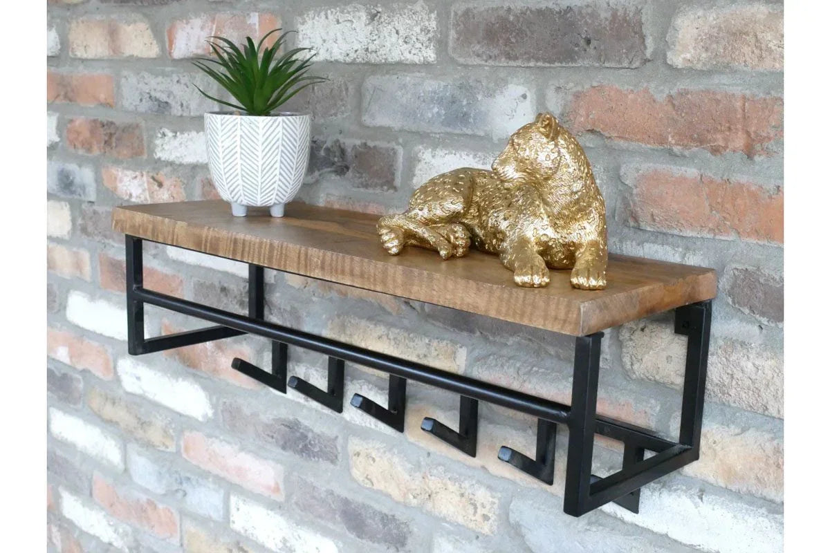 Industrial wall shelf with black metal hooks, wood top, potted plant and gold cheetah décor