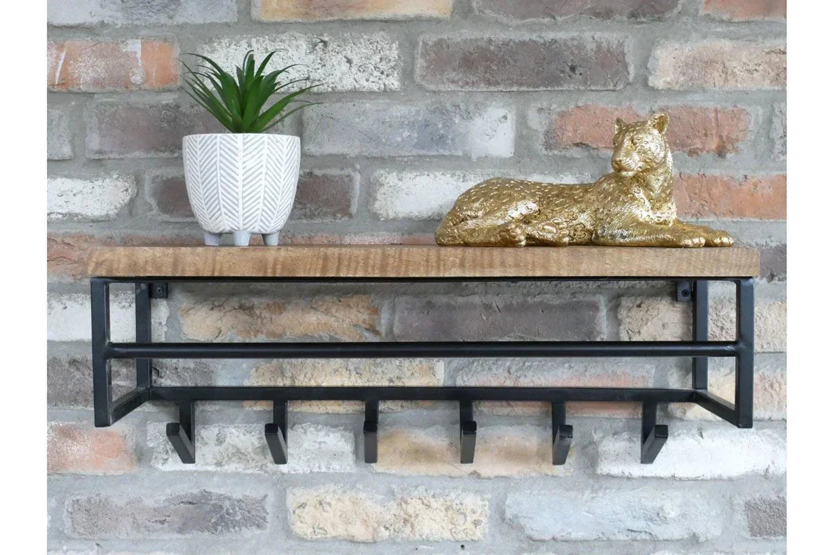 Wood and metal wall shelf with black hooks, plant pot, and gold leopard ornament
