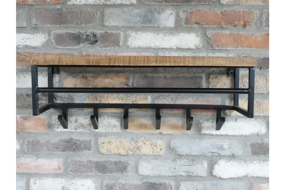 Wall mounted coat rack with wooden shelf and black metal hooks on exposed brick wall