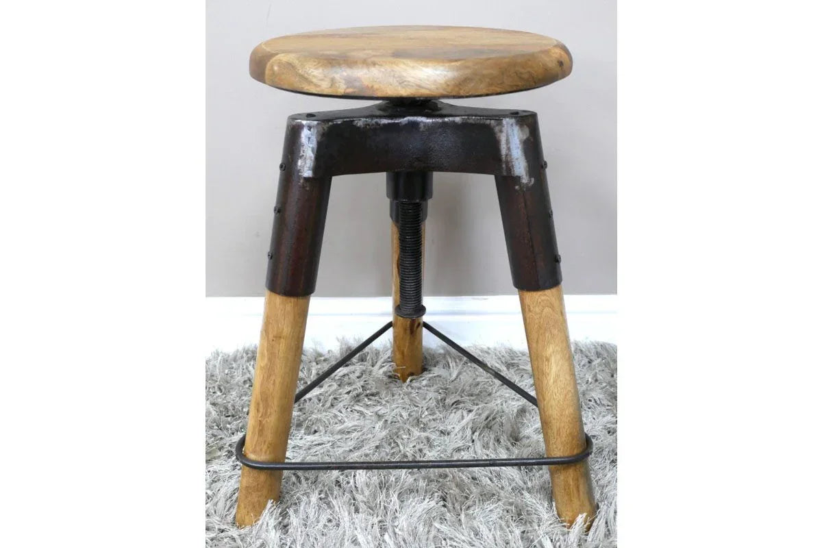 Industrial wooden stool with metal frame and round seat on grey rug