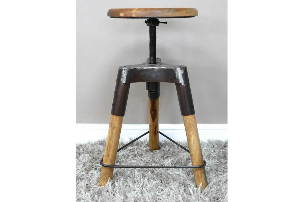 Industrial bar stool with adjustable wooden seat and metal legs on grey rug