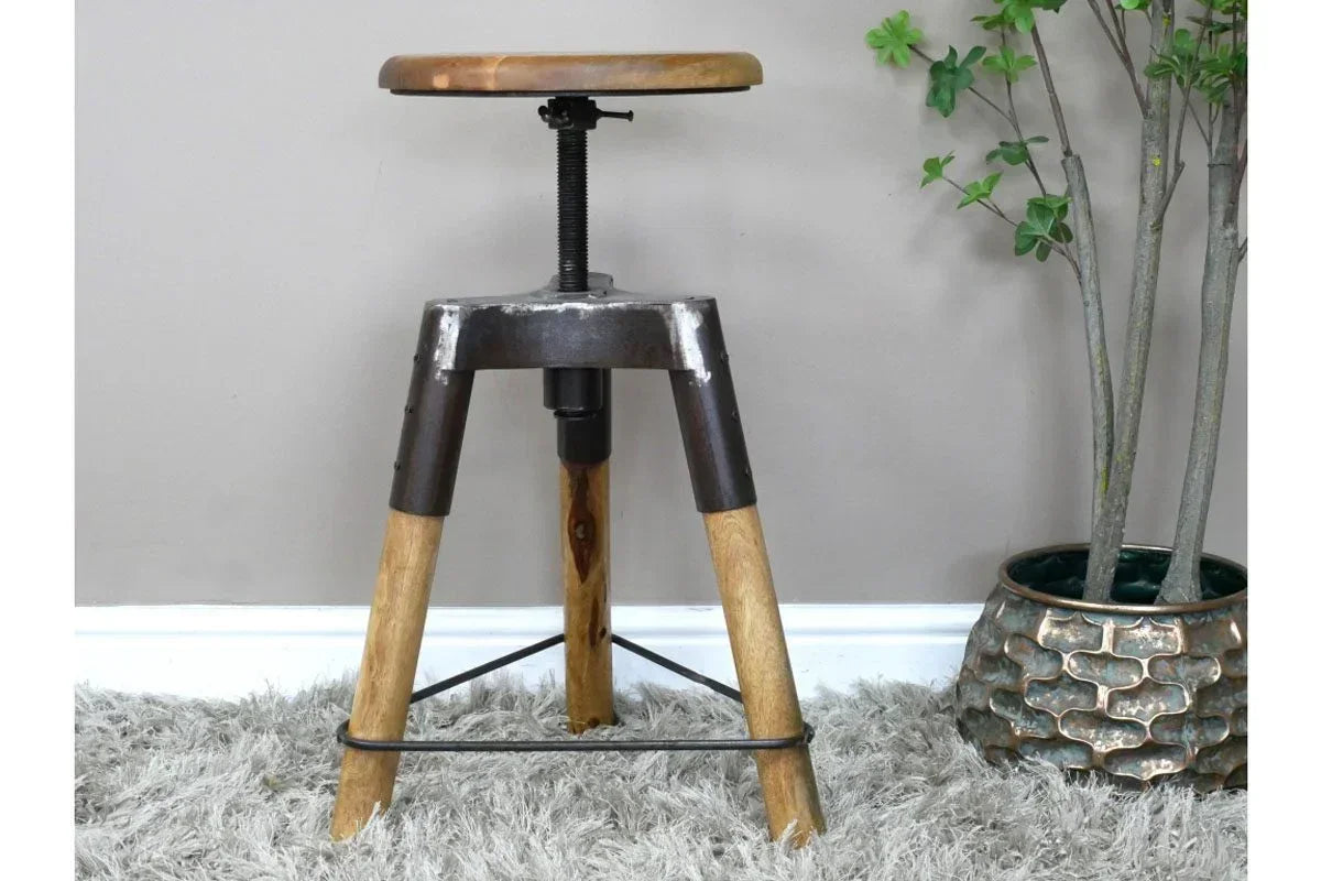 Industrial style adjustable bar stool with wooden seat and metal legs on grey rug