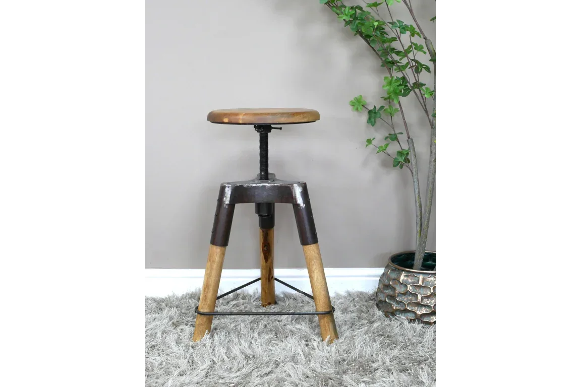 Industrial adjustable bar stool with wooden seat and metal legs on grey rug