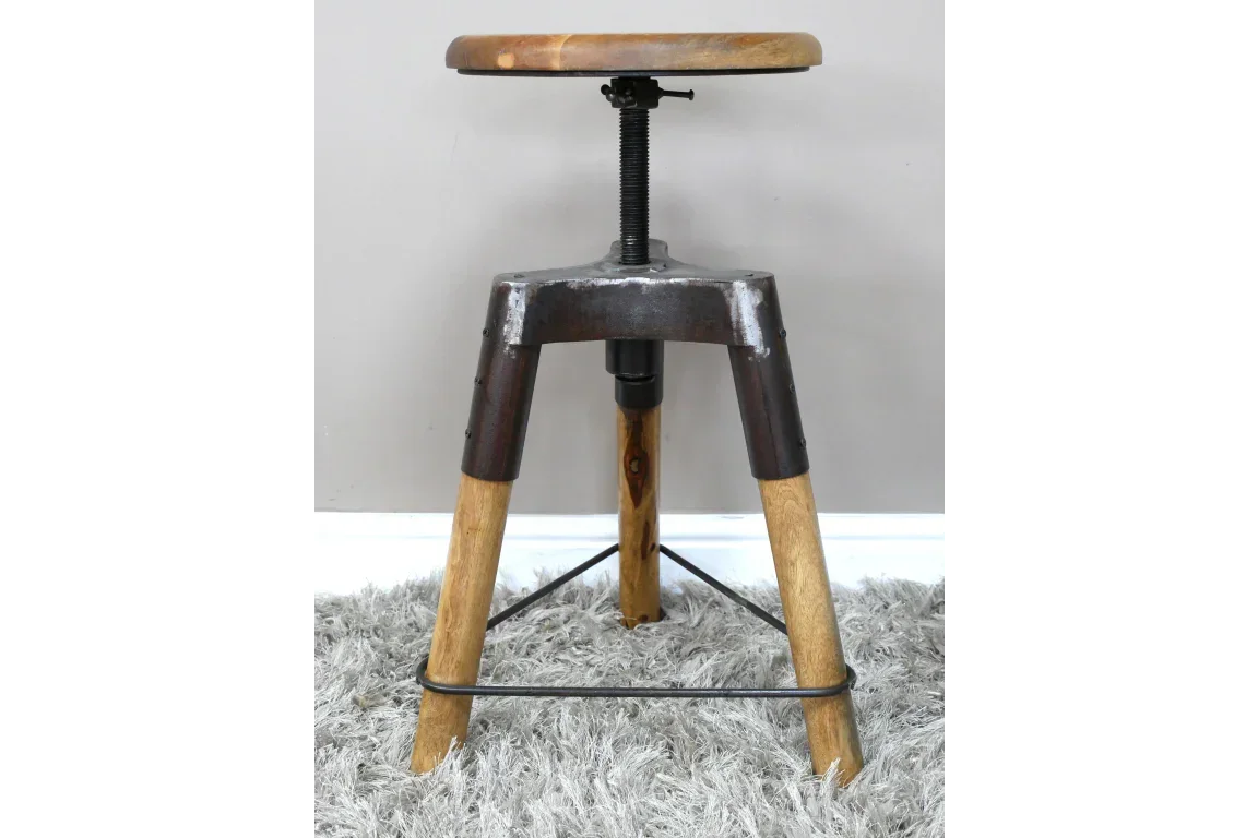 Industrial style wooden bar stool with metal legs and adjustable seat on grey rug
