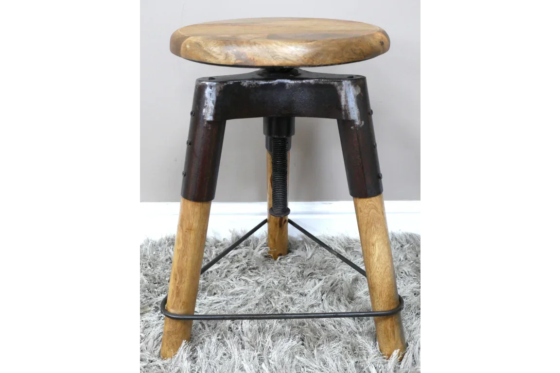 Industrial bar stool with wooden seat, metal frame, and adjustable screw detail on grey rug