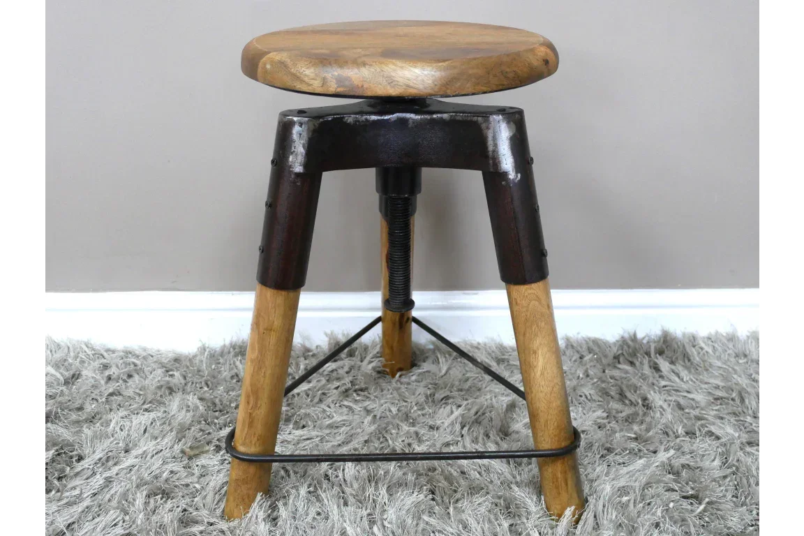 Industrial style wooden stool with metal legs on grey carpet