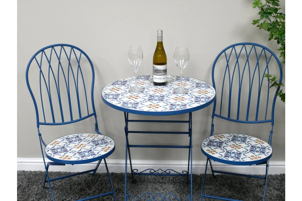 blue metal bistro set with patterned table and chairs, wine bottle and glasses on tabletop